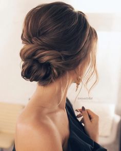 a woman with her hair in a low bun