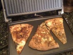 three slices of pizza sitting on top of a grill