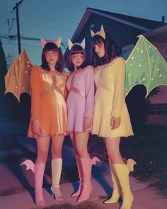 three women dressed in costumes standing next to each other