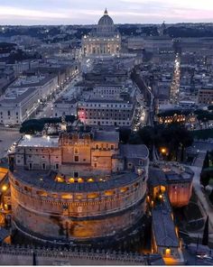 an aerial view of a city at night with buildings and lights in the foreground