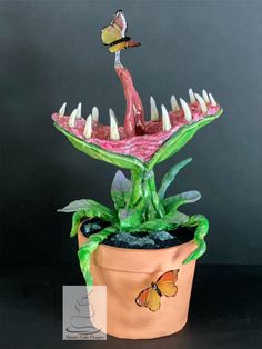 a potted plant with spikes and a butterfly sitting on it's back end