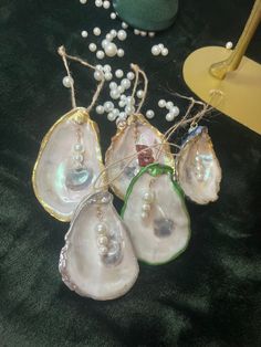 four pieces of glass with pearls hanging from them