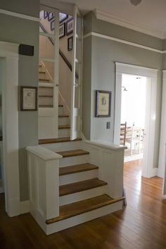 an empty house with wood floors and stairs