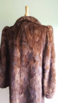 Old Hollywood glamour ✨📸 This vintage 1940s-style glossy mink coat features dramatic puffed sleeves, with padding at shoulders for structure and lift and elasticized wrists; a face-framing portrait collar; a deco-inspired geometric pattern to the fur; two pockets; and a sleek, longer length. Hidden front hook closures, fully lined. Monogrammed CHC. Era: 1960s Label: Strouss Pictured on a US size 6/8 dress form. ➸ visit on instagram | provenance_vintage Elegant Brown Long Fur Coat, Elegant Long Brown Fur Coat, Mink-colored Faux Fur Coat For Evening, Mink-colored Faux Fur Evening Coat, Brown Winter Wedding Outerwear, Evening Mink-colored Faux Fur Coat, Winter Wedding Brown Outerwear, Brown Winter Fur Coat For Formal Occasions, Brown Fur Coat For Formal Winter Occasions