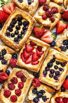 fresh fruit tarts are arranged on a white surface