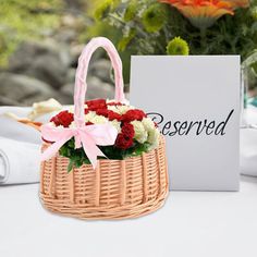 a basket filled with flowers sitting on top of a table next to a sign that says reserved