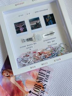 a white frame with some pictures and jewelry in it