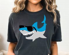 a woman wearing a t - shirt with a shark on it