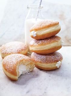 a stack of doughnuts sitting on top of a counter next to a bottle of milk