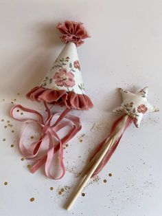 two pink and white party hats on top of each other next to a pair of toothbrushes