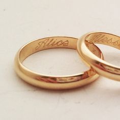 two gold wedding rings with names engraved on them