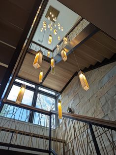 the lights are hanging from the ceiling in the building's atrium area, which is decorated with stone walls and metal railings