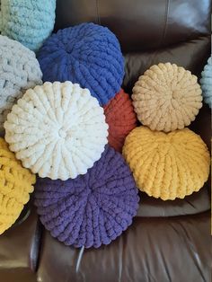 a group of knitted pillows sitting on top of a leather chair