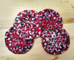 three red and white pieces of fabric sitting on top of a wooden table