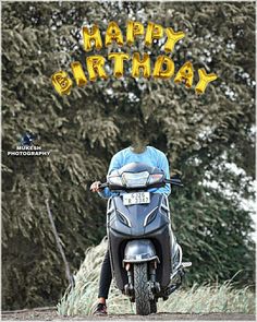 a man riding on the back of a motorcycle down a road next to a forest