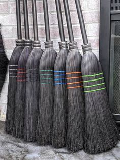 six black brooms lined up next to each other