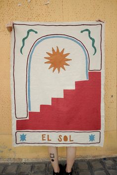 a woman is holding up a towel with the words el sol in spanish on it