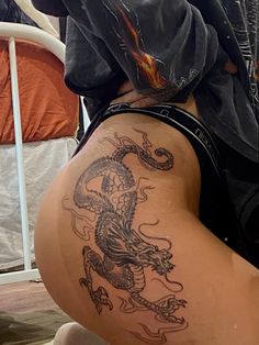 a woman with a dragon tattoo on her thigh