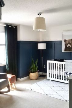 a baby's room with blue walls and white furniture