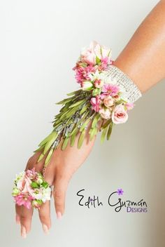 a woman's hand holding a bouquet of pink and white flowers on her wrist