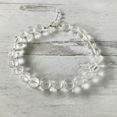 We love the look of this vintage clear lucite (acrylic) round beads statement necklace! Each bead is 5/8" or 16mm in diameter. The necklace can be worn from 17" to 20" long, depending on where the hook is clasped along the wired wrap bead chain. The clasp is gold plated, and the necklace is unsigned. It is in excellent condition, a really fun statement necklace. Clear Bead Necklace, Adjustable Clear Necklace, Clear Single Strand Crystal Necklace With Round Beads, Clear Crystal Single Strand Necklace With Round Beads, Clear Crystal Necklace With Single Strand Of Round Beads, Clear Glass Round Bead Necklaces, Clear Glass Round Beads Necklaces, Clear Glass Beaded Necklaces, Clear Glass Necklaces With Round Beads