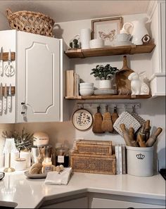 a kitchen with white cabinets and shelves filled with cooking utensils