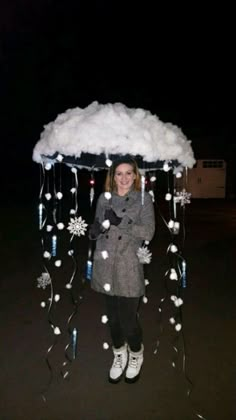 a woman is standing under an umbrella with snowflakes on it and lights hanging down