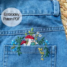 an embroidered patch in the back pocket of a pair of blue jeans with flowers and mushrooms on them