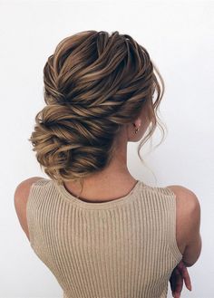 a woman with her back to the camera, braided into a low bun hairstyle