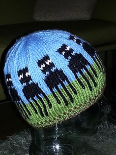 a blue and green knitted hat sitting on top of a table