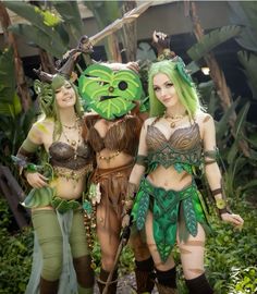 three women in costume standing next to each other with plants on their heads and body