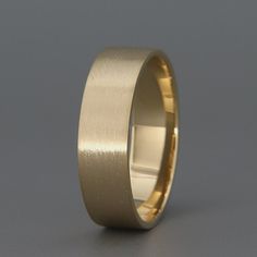 a gold wedding ring on a grey background