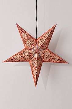 an origami star hanging on a wall