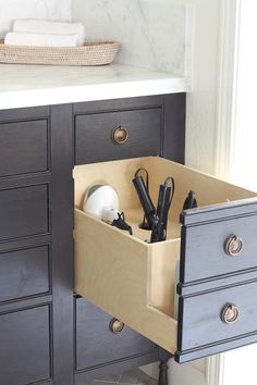 an open drawer in a kitchen with utensils