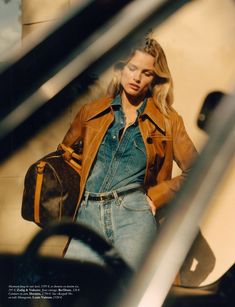 a woman with a handbag standing next to some stairs