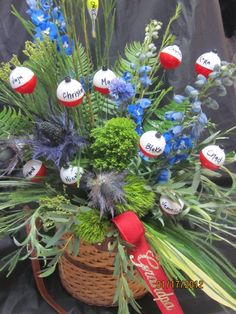 a basket filled with lots of green plants and red white and blue balls in it