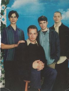 a group of young men standing next to each other in front of a blue sky