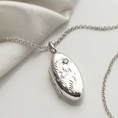 "This sterling silver oval locket, makes a wonderful keepsake, and memorable gift.  The front features a beautiful floral design and the back is blank, ideal for engraving a name, date or short message. The perfect sentimental gift for a friend or loved one. So why not make this a truly personal gift by having your own special message engraved, by us, on this eye catching locket. To order this locket simply select the chain length and the font you would like us to use from the drop down menus, you can select \"no engraving\" if you would like us to leave it blank. Then at the checkout enter the message you would like us to engrave in the \"note to seller\" box. Ideally 30 characters fits best on this locket. Both the locket and the chain are made from sterling silver. The locket measures 3 Silver Locket Necklace With Birth Flower For Anniversary, Silver Oval Jewelry With Birth Flower Detail, Silver Oval Jewelry With Birth Flower, Silver Locket Necklace With Birth Flower Round Pendant, Silver Oval Locket Necklace With Engraving Option, Oval White Gold Locket Necklace For Keepsake, White Gold Oval Locket Necklace For Keepsake, Oval White Gold Locket Necklace Keepsake, Silver Wedding Locket Necklace With Birth Flower