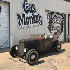 an old car is parked in front of a gas monkey sign on the side of a building