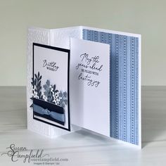 a handmade greeting card with blue and white flowers on it, in the middle of an open fold