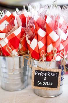 red and white candy sticks are in a bucket with a sign that says pitchforks & shovels