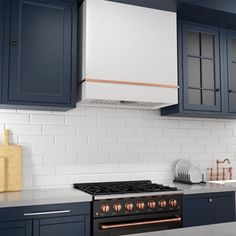 a stove top oven sitting inside of a kitchen next to blue cabinets and counter tops