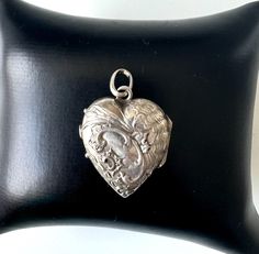 Immerse yourself in the magical world of Art Nouveau with this exquisite heart locket made of 800 silver, a piece of jewelry that tells stories of times gone by. This unique pendant, artfully designed in the romantic era of Art Nouveau, is a real eye-catcher and a piece that will make the hearts of antique lovers beat faster. The locket gently opens to reveal two small niches for personal pictures or a beloved keepsake, ideal for carrying close hearts or moments with you at all times. Closed, it Victorian Heart Charm Locket Necklace, Victorian Heart Charm Locket Pendant Necklace, Silver Heart Pendant Locket Necklace With Vintage Charm, Silver Heart Locket Necklace Spiritual Style, Victorian Silver Locket Necklace With Heart Charm, Silver Heart Charm Locket Necklace For Memorial, Silver Heart Pendant Locket For Memorial, Silver Heart Pendant Locket Necklace For Memorial, Handmade Silver Locket Necklace For Valentine's Day