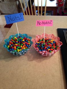 two bowls filled with candy sitting on top of a table