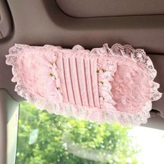 pink lace garter hanging from the side of a car seat in front of a window