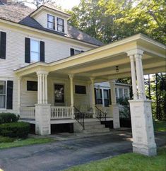 a white house with black shutters on the front porch