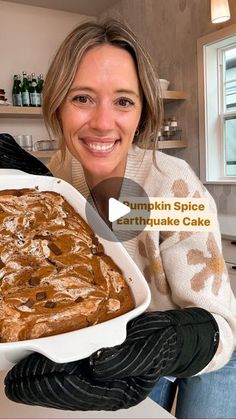 a woman is holding a large pan of pumpkin spice earthwake cake in the kitchen