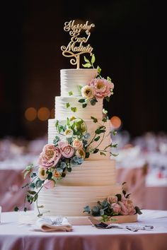 a wedding cake with flowers on it and the top tier has a sign that says happily married