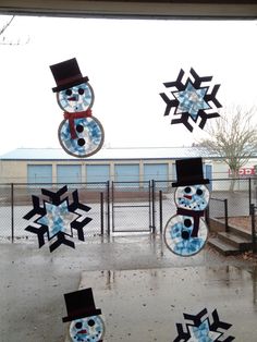 snowmen made out of glass sitting on top of a window sill in front of a building