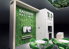 a booth with green chairs and a television on the wall that says radisson meetings